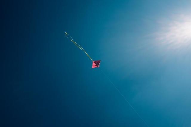 minimalist-pink-kite-dots-through-blue-skies.jpg